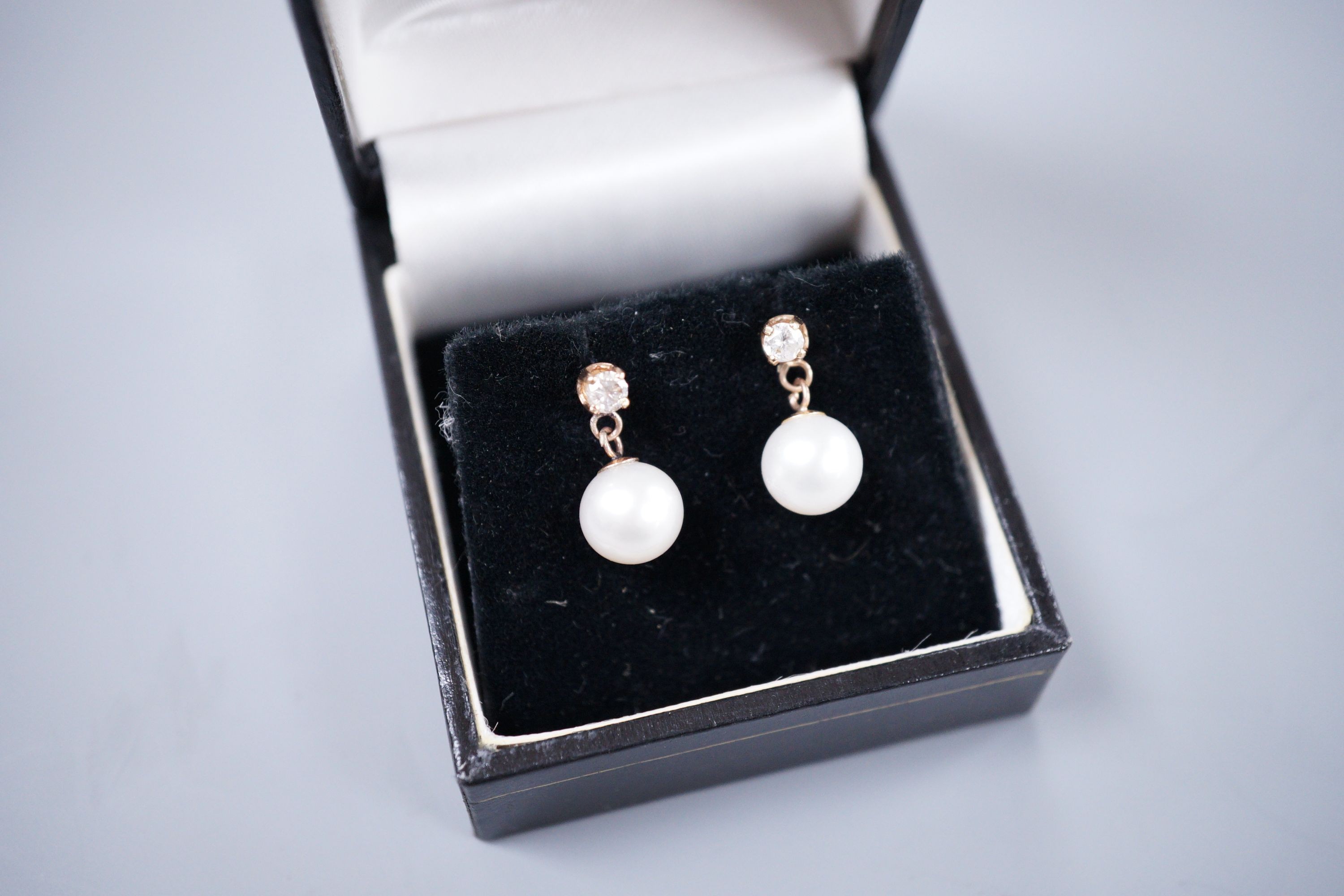 A pair of gold mounted diamond and cultured pearl drop earrings